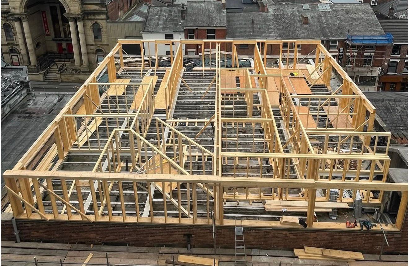 On-site timber frame for two master apartments under new roof