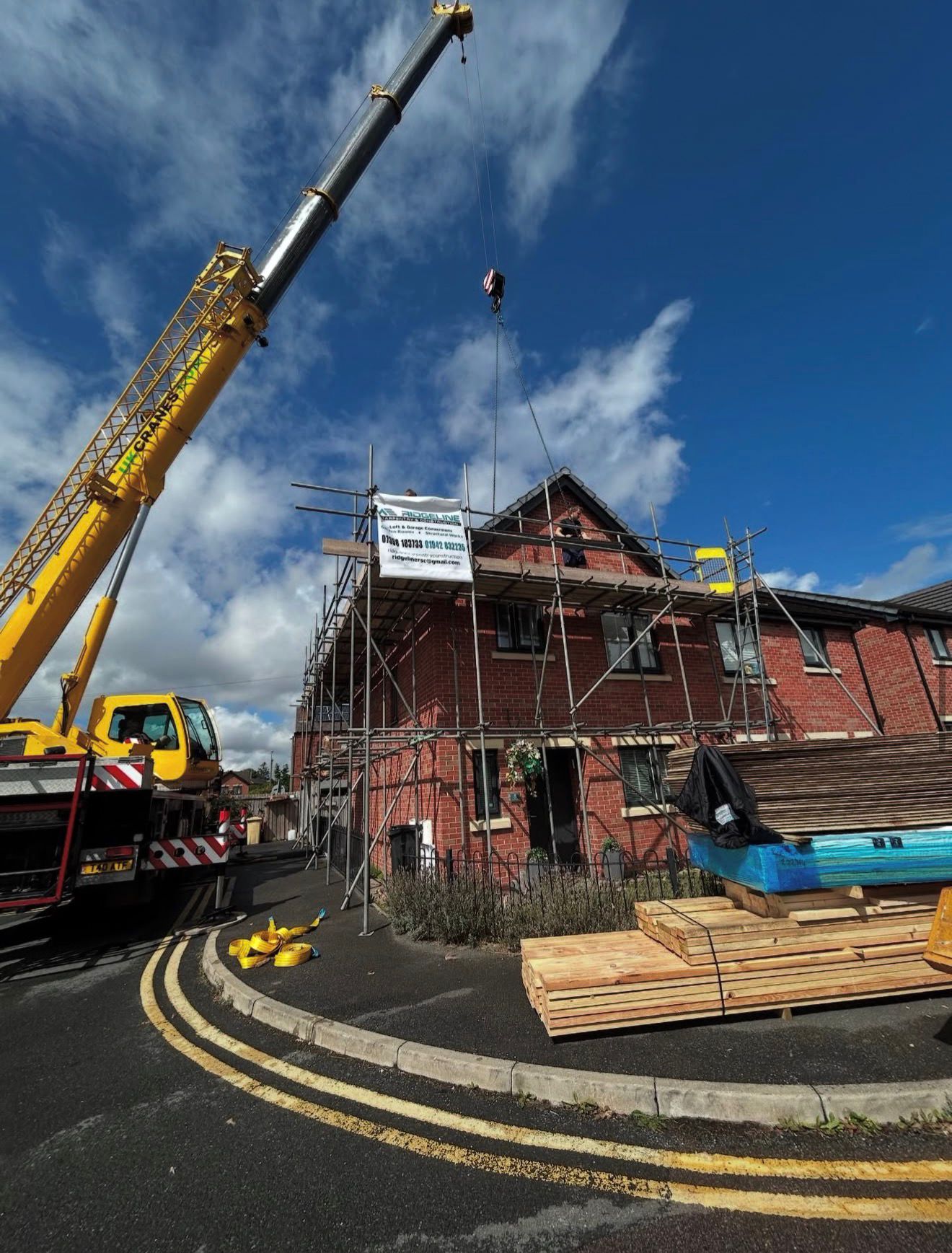 Crane lift delivering dormer loft conversion timbers to a Westhoughton property